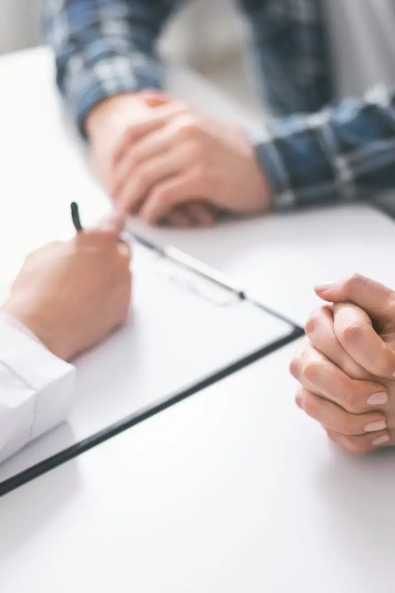 Medical consultation. Doctor writing prescription and treatment plan to couple of patients at clinic